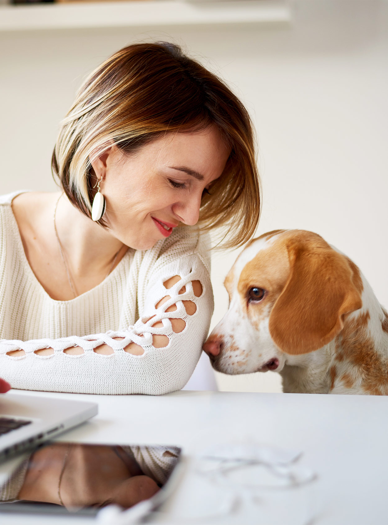 lady sitting next to a sad beagle to illustrate can humans get kennel cough